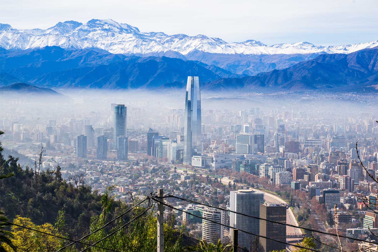 Panoramablick auf Santiago de Chile - Großstadt vor Kulisse mit schneebedeckten Bergen.