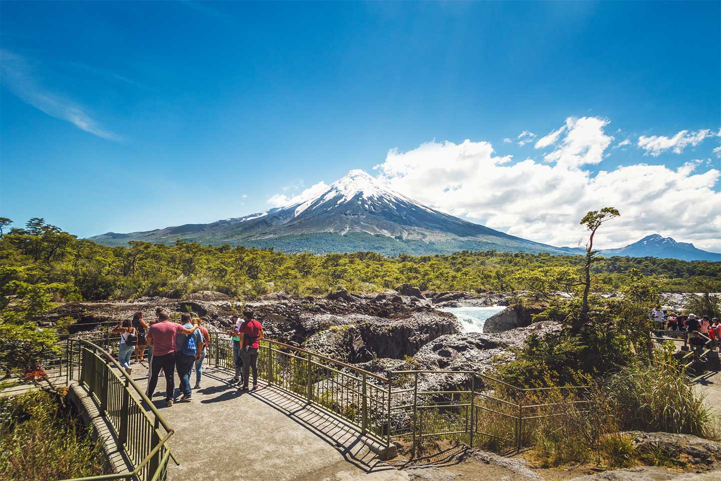 Touristen schauen von einer Aussichtsplattform auf den Vulkan Osorno