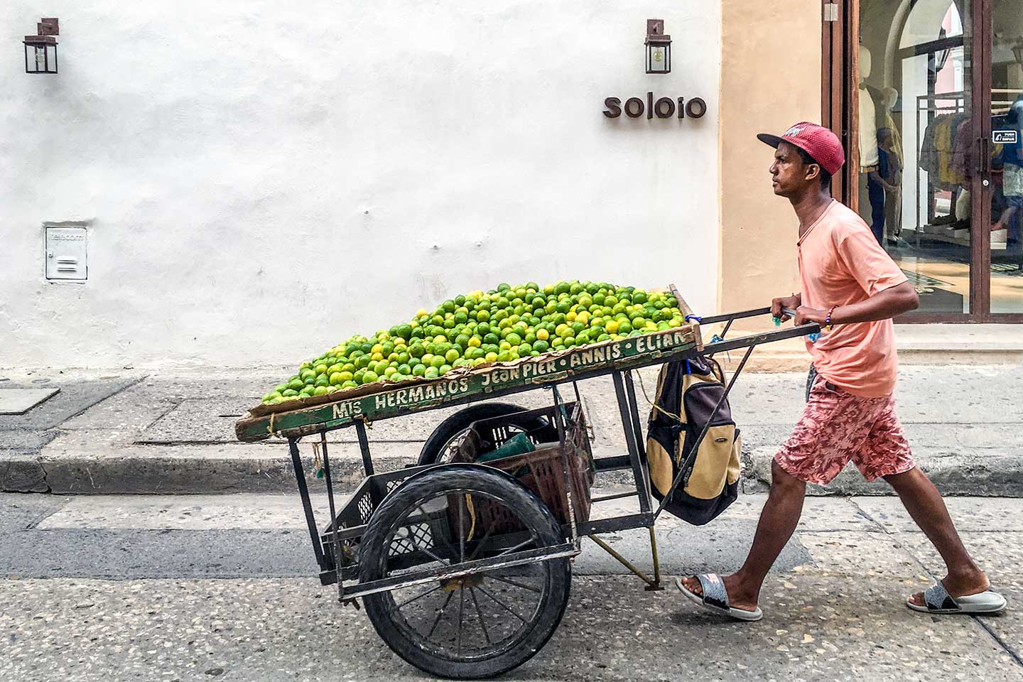 Ein Mann in Cartagena transportiert Limonen duch die Straßen. Sie liegen auf einem großen Karren