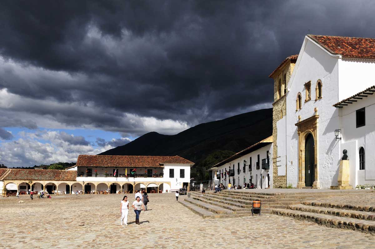 Über einem Platz in Villa de Leyva in Kolumbien ziehen sich graue Wolken zusammen