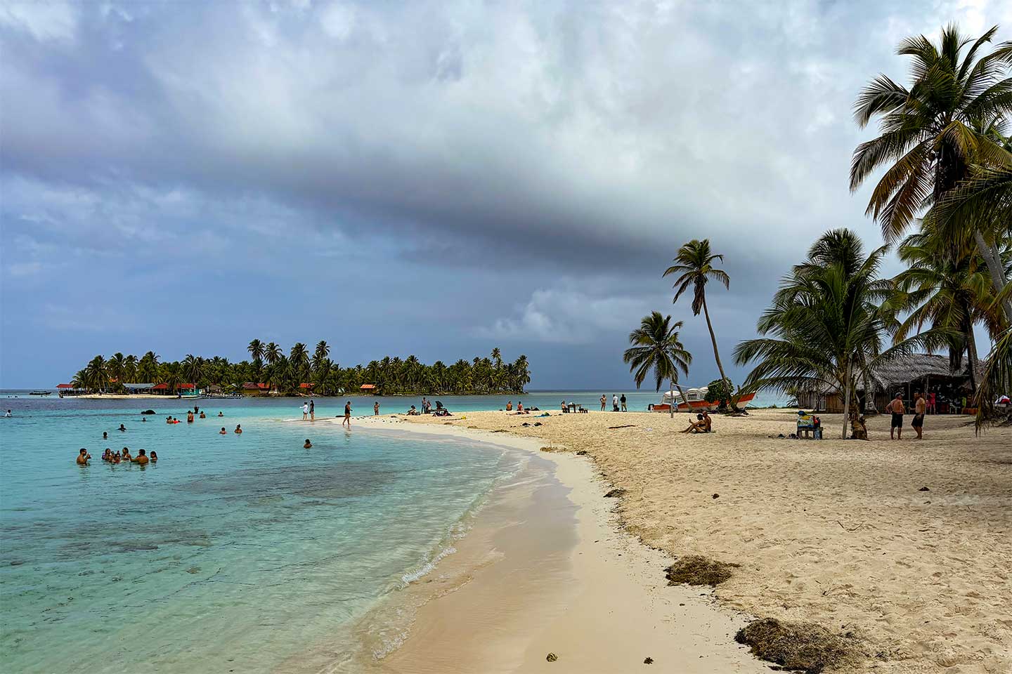 Ein Badestrand an der Karibikküste in Panama. Menschen baden in türkisblauem Wasser.